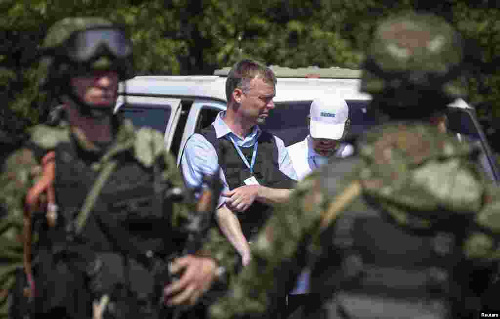 Alexander Hug (center), deputy head of the OSCE monitoring mission in Ukraine, nex to armed pro-Russian separatists on the way to the site in eastern Ukraine where the downed Malaysia Airlines flight MH17 crashed, near Donetsk, July 30, 2014.