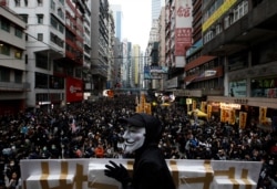 An anti-government protester wears a Guy Fawkes mask during a demonstration on New Year's Day to call for better governance and democratic reforms in Hong Kong, Jan. 1, 2020.