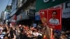 A protester holds up a sign with the images of detained Myanmar civilian leader Aung San Suu Kyi, right, and president Win Myint during a demonstration against the military coup in Yangon, Myanmar, on Feb. 6, 2021.