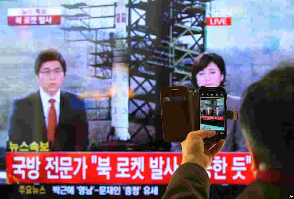 South Korean man uses his smartphone to take a photo of television screen reporting news about North Korea's rocket launch at Seoul Railway Station in Seoul, South Korea, Dec. 12, 2012.