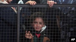 A Palestinian girl waits with her family for their turn to enter the Rafah border crossing with Egypt, in the southern Gaza Strip, May 11, 2016.