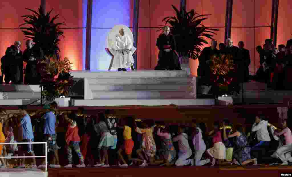 Pope Francis sits on a stage watching youths acting out a skit during the Catholic Church's World Day of Youth at Copacabana beach in Rio de Janeiro, July 25, 2013. Pope Francis is on the fourth day of his week-long visit for World Youth Day. REUTERS/Ri