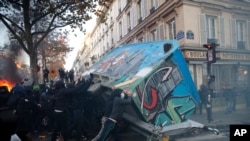 Youths overturn a construction hut during a demonstration against a security law that would restrict sharing images of police, Nov. 28, 2020 in Paris. 