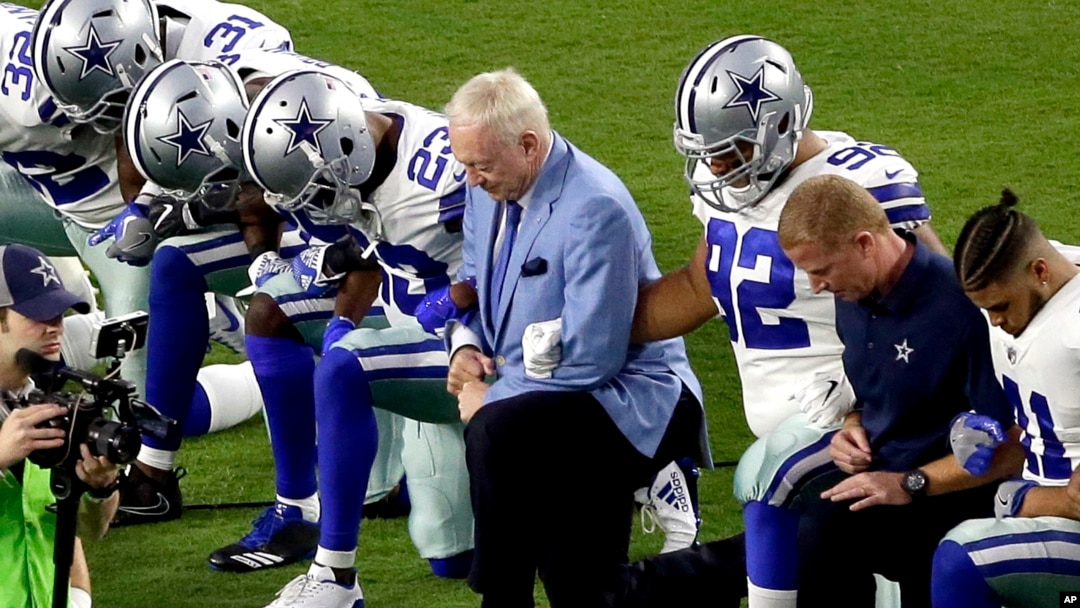 Jerry Jones (tengah) pemilik klub NFL Dallas Cowboys berlutut bersama pelatih dan para pemain Cowboys sebelum pertandingan di Glendale, Arizona, Senin (25/9) lalu. 