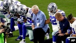 Jerry Jones (tengah) pemilik klub NFL Dallas Cowboys berlutut bersama pelatih dan para pemain Cowboys sebelum pertandingan di Glendale, Arizona, Senin (25/9) lalu. 