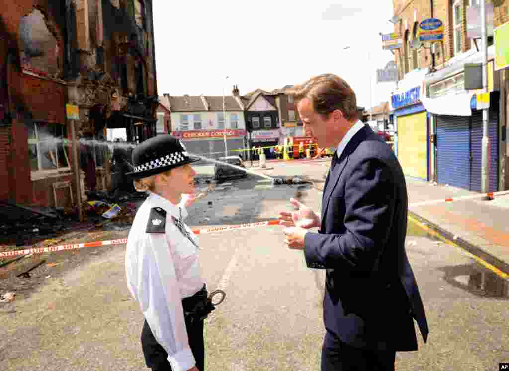 August 9: Britain's Prime Minister David Cameron speaks with acting borough commander, Superintendent Jo Oakley, in south London. REUTERS/Stefan Rousseau