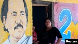 Una mujer sentada junto a una imagen del presidente de Nicaragua, Daniel Ortega, en Catarina, Nicaragua, el 1 de octubre de 2020.