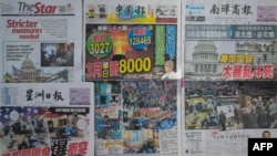 This photo illustration taken in Karak, Malaysia's Pahang State on January 8, 2021 shows the frontpages of Malaysia’s newspapers carrying stories and pictures of supporters of US President Donald Trump protesting inside and outside the US Capitol.