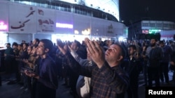 People pray for the well-being of Iran's President Ebrahim Raisi following the crash of a helicopter carrying him, in Tehran