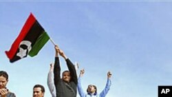 利比亚人在坦克上挥动前卡扎菲时代国旗