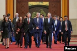 美国参议员丹恩斯和国会代表团成员在美国大使珀杜陪同下走在北京的中国人民大会堂，准备会晤中国总理李强。(2026年5月7日)
