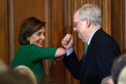 FILE - House Speaker Nancy Pelosi of California, left, and Senate Majority Leader Mitch McConnell of Kentucky bump elbows on Capitol Hill in Washington, March 12, 2020.