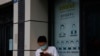 A resident wearing a mask to curb the spread of the coronavirus stand near a shuttered store that offered visa application services outside the United States Consulate in Chengdu in southwestern China's Sichuan province, July 25, 2020. 