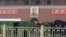 Police officers set up barriers in front of the giant portrait of the late Chinese Chairman Mao Zedong as they clean up after a car accident at Tiananmen Square in Beijing, Oct. 28, 2013. 