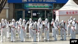 Tentara Korea Selatan dengan baju hazmat menyemprotkan cairan disinfektan sebagai upaya mencegah penyebaran virus korona COVID-19, di Balai Kota Daegu, 2 Maret 2020. (Foto: AFP)