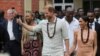 Britain's Prince Harry, Duke of Sussex and his wife Meghan, Duchess of Sussex, walk out after meeting the students at the Lightway Academy in Abuja, Nigeria, May 10, 2024