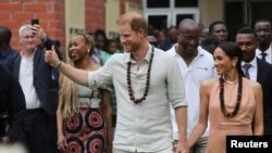 Britain's Prince Harry, Duke of Sussex and his wife Meghan, Duchess of Sussex, walk out after meeting the students at the Lightway Academy in Abuja, Nigeria, May 10, 2024