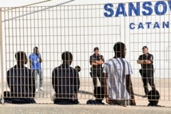 Some of migrant minors allowed to disembark the Open Arms vessel, anchored off the Sicilian vacation and fishing island of Lampedusa, southern Italy, wait to be taken to the Sicilian port of Porto Empedocle from Lampedusa, Aug. 19, 2019.