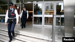 Police officers leave the Polish Social and Cultural Association after graffiti was painted on the side of the building calling on Poles to leave the United Kingdom, in Hammersmith, London, Britain June 27, 2016. 