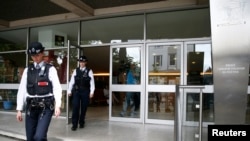 Polisi meninggalkan gedung Asosiasi Sosial Budaya Polandia, tempat adanya grafiti yang menyerukan orang-orang Polandia untuk pulang ke negaranya, di Hammersmith, London (27/6). (Reuters/Neil Hall)