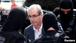 Former speaker of Brazil's Lower House of Congress, Eduardo Cunha (C), is escorted by federal police officers as he leaves the Institute of Forensic Science in Curitiba, Oct. 20, 2016. 