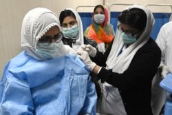 Seorang dokter menerima satu dosis vaksin COVID-19 Sinopharm buatan China, di pusat vaksinasi di Lahore, 3 Februari 2021.