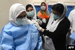 Seorang dokter menerima satu dosis vaksin COVID-19 Sinopharm buatan China, di pusat vaksinasi di Lahore, 3 Februari 2021.