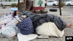 A displaced girl sleeps on the sidewalk in downtown Beirut on Oct. 1, 2024. Intense Israeli attacks have forced up to 1 million people to flee parts of Lebanon, authorities say.