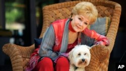 Debbie Reynolds, yang ikut berperan dalam film "Behind the Candelabra," berpose bersama anjingnya, Dwight, di Beverly Hills, California, 21 Mei 2013. Reynolds meninggal dunia di usia 84 tahun, Rabu siang (28/12) sehari setelah putrinya, Carrie Fisher tutup usia.