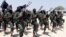 FILE - hundreds of newly trained al-Shabab fighters perform military exercises in the Lafofe area some 18 km south of Mogadishu, in Somalia. 