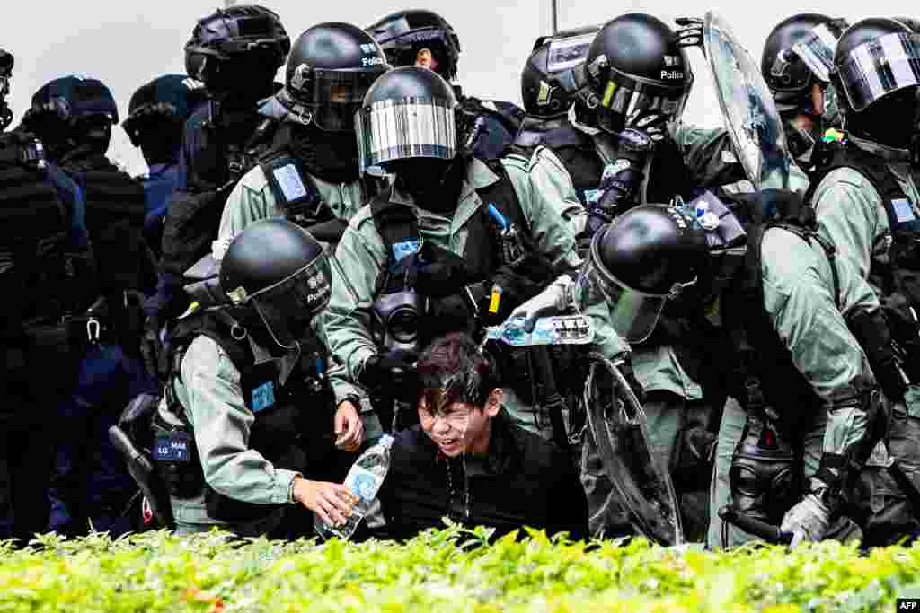 Riot police wash the face of a protester who was pepper sprayed while getting detained after an anti-parallel trading protest at Sheung Shui, a border town in Hong Kong, Jan. 5, 2020.