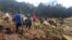 Residents walk on top of a landslide at Yambali, Papua New Guinea, on May 25, 2024. (International Organization for Migration via AFP)