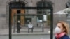 People wearing protective face masks wait at a public transport stop as a pedestrian walks nearby amid the coronavirus disease (COVID-19) outbreak in central Kiev, Ukraine June 2, 2020.