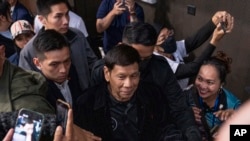 Mantan Presiden Filipina Rodrigo Duterte tiba di Stadion Southhorn di Hong Kong untuk bertemu dengan pekerja migran asal Filipina di wilayah tersebut pada 9 Maret 2025. (Foto: AP/Vernon Yuen)