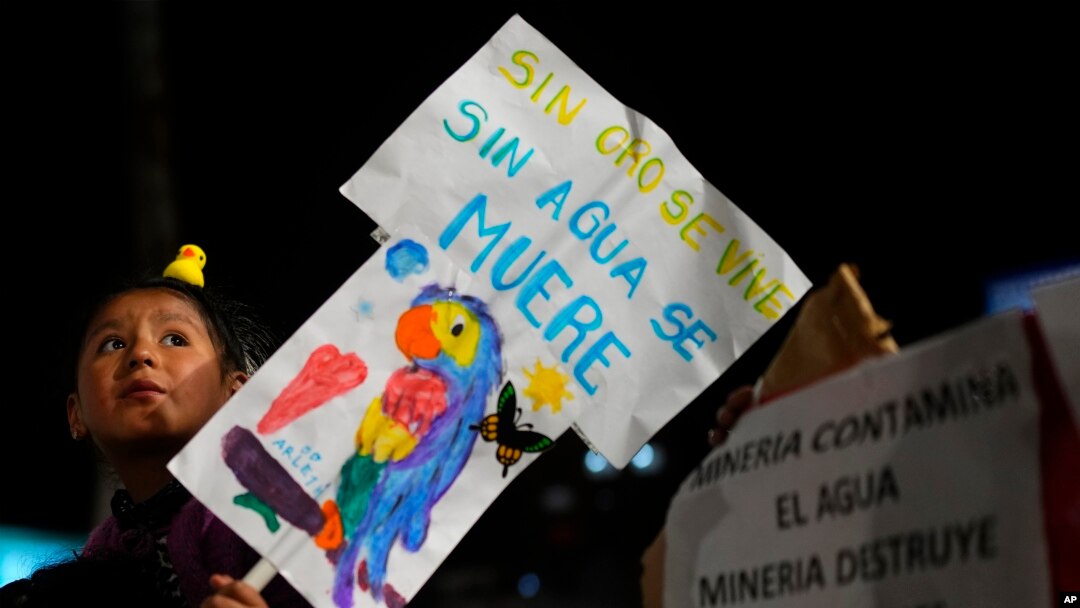 Una niña sostiene un cartel con mensaje llamando a la reflexión, durante una protesta contra los incendios forestales y la minería de oro en tierras protegidas, en La Paz, Bolivia, el 17 de noviembre de 2023.