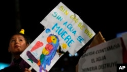 Una niña sostiene un cartel con mensaje llamando a la reflexión, durante una protesta contra los incendios forestales y la minería de oro en tierras protegidas, en La Paz, Bolivia, el 17 de noviembre de 2023.