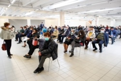 People wait to receive a dose of AstraZeneca coronavirus disease (COVID-19) vaccine in Fasano, Italy, Apr. 13, 2020.