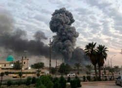 FILE - Plumes of smoke rise after an explosion at a military base southwest of Baghdad, Iraq, Aug. 12, 2019.