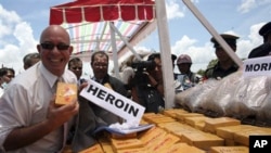 Ross Dunkley, the editor-in-chief of the English-language Myanmar Times, poses for a photo with packs of heroin during a ceremony to destroy seized narcotic drugs in Lashio, northeast of Rangoon, Burma (FILE)