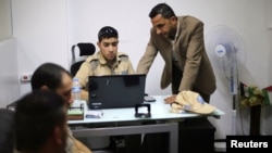 Palestinian Akram Al-Balawi (R), director of Castle Security company, speaks with a private security guard in the company's office in Gaza City, Nov. 21, 2016.
