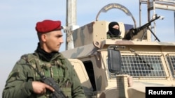 FILE - A member of Kurdish-led Syrian Democratic Forces stands along a street after rebels seized the capital and ousted Syria's Bashar al-Assad, in Hasakah, Syria, Dec. 11, 2024.