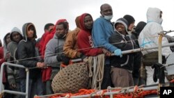 Migrants wait to disembark from a tug boat after being rescued in Porto Empedocle, Sicily, southern Italy, Feb. 17, 2015.