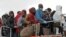 FILE - Migrants wait to disembark from a tug boat after being rescued in Porto Empedocle, Sicily, southern Italy, Feb. 17, 2015.