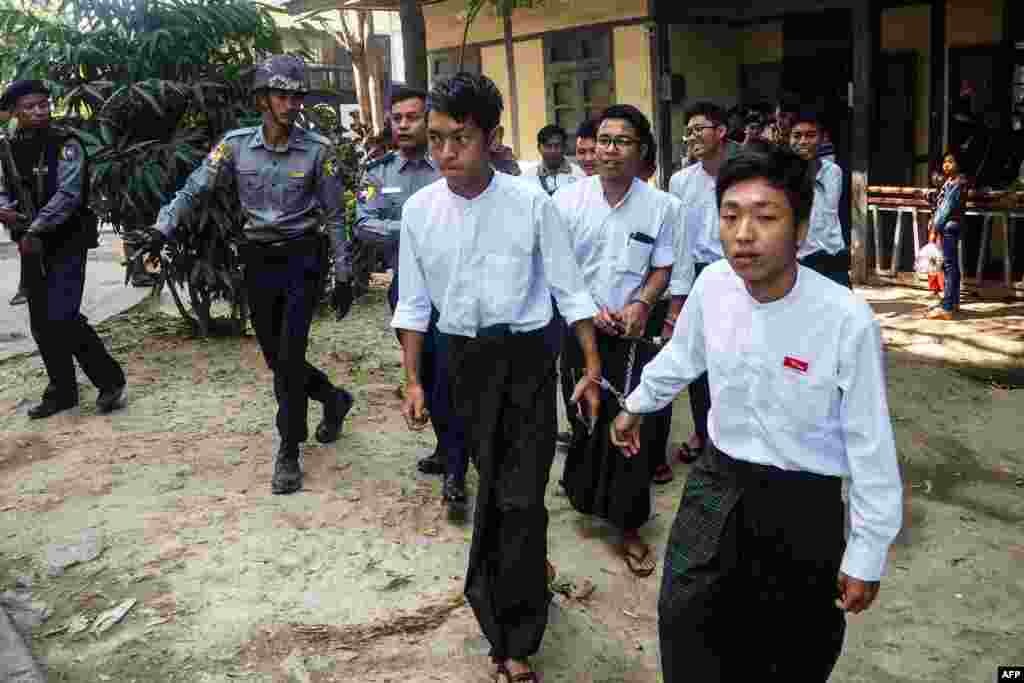 Students are escorted by police after a court hearing in Mandalay, Myanmar. Seven students were sentenced to three months in jail with hard labor for burning portraits of officials in protest over campus safety, a student activist said.