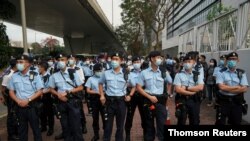 Agentes de policía apoyan a activistas a favor de la democracia que enfrentan cargos relacionados con la seguridad nacional y se reúnen frente a los tribunales de magistrados de West Kowloon, en Hong Kong, China, el 1 de marzo de 2021.