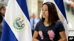 Tania Vanessa Avalos se detiene cerca de donde un miembro del gobierno da una conferencia de prensa después de su llegada a San Salvador, El Salvador, el jueves 28 de junio de 2019. Ella es la esposa del hombre que se ahogó junto con su hija de 23 meses tratando de cruzar Río Bra