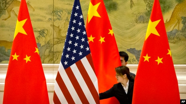 资料照: 在北京钓鱼台国宾馆,中方工作人员在美中贸易谈判开始前摆放两国国旗(2019年2月14日)