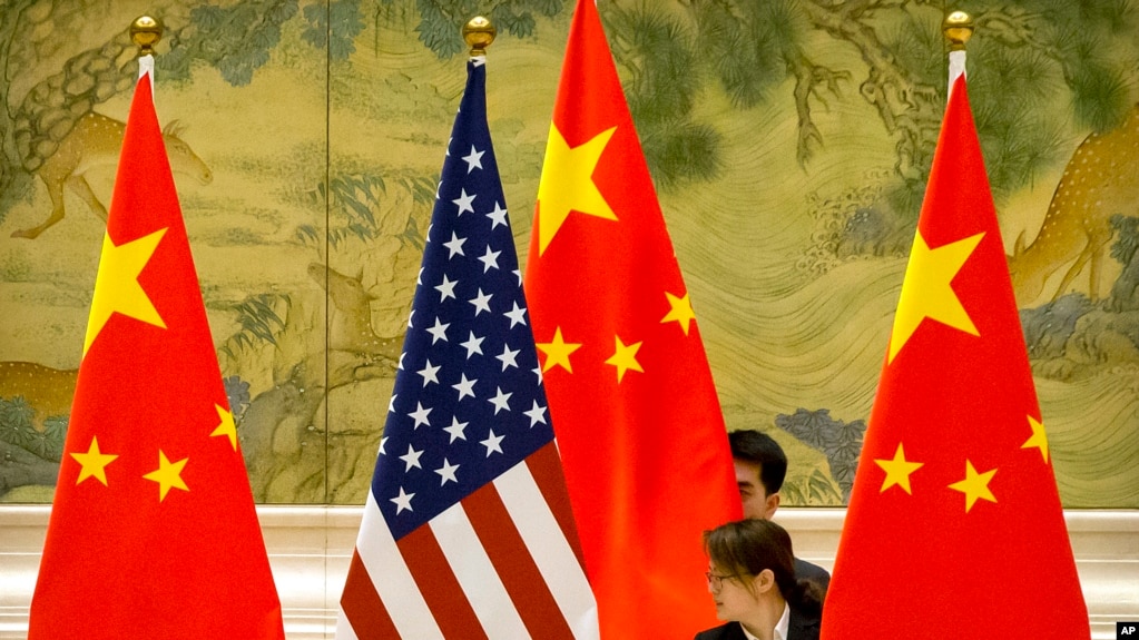 资料照： 在北京钓鱼台国宾馆，中方工作人员在美中贸易谈判开始前摆放两国国旗（2019年2月14日）(photo:VOA)