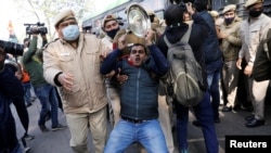 Police officers detain an activist of the youth wing of India's main opposition Congress party during a protest against new farm laws in New Delhi, India, Jan. 12, 2021. 