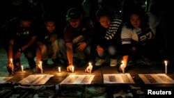 Football supporters from East Java hold a vigil for victims of the suicide bomb attacks in Surabaya at a city park in Jakarta, Indonesia, May 14, 2018. 